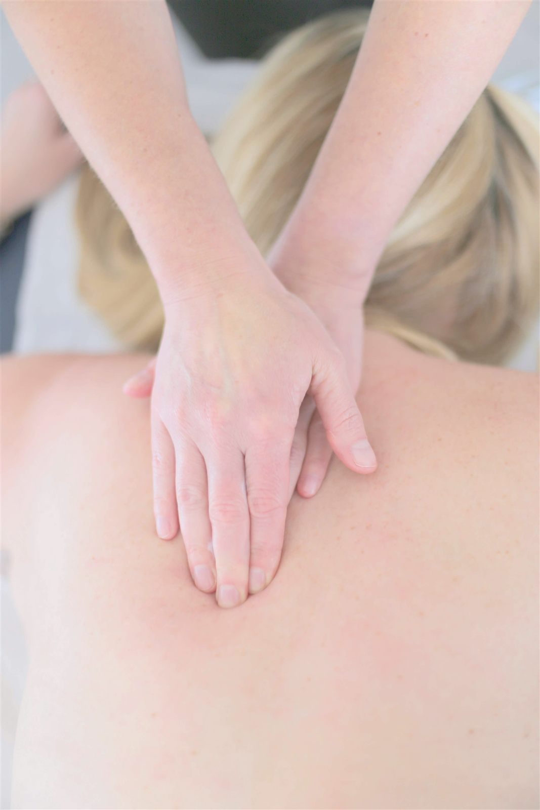 One gentle hand resting on the mid-back